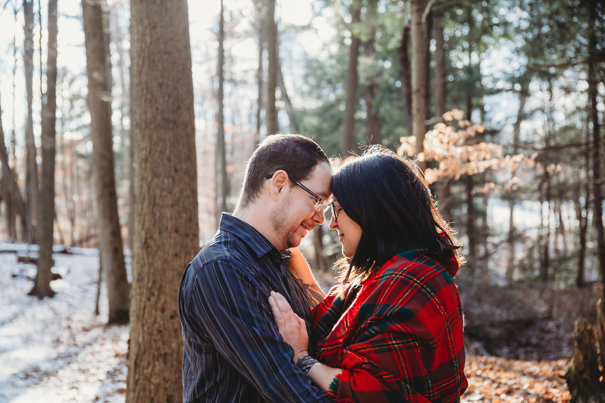 Andy & Erin embrace in the forest of Dundas Conservation Area in the winter during their maternity photoshoot with Dundas Maternity Photographer Jennifer Blaak.