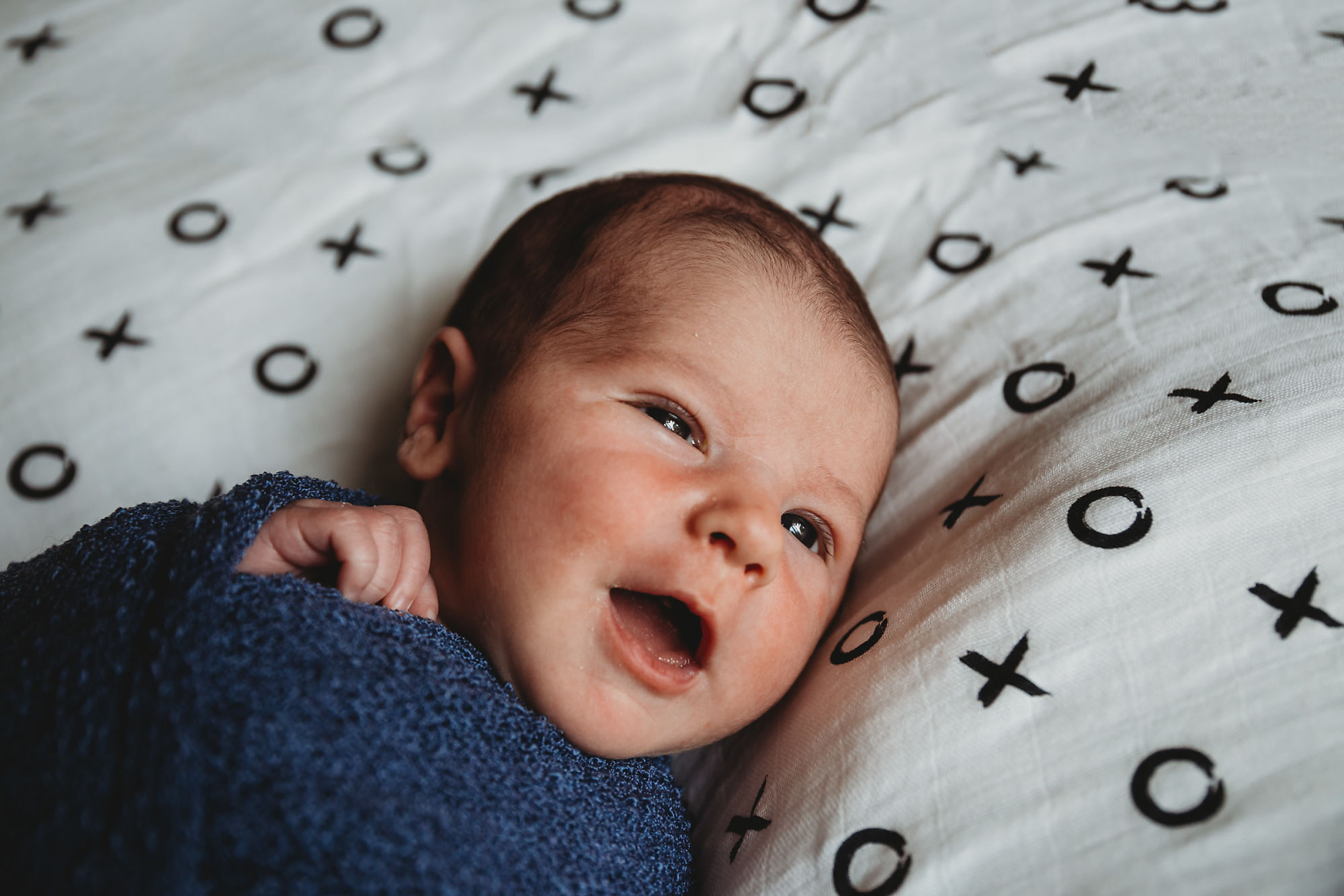 Dundas Newborn Photographer Jennifer Blaak captures a gentle smile from baby during their newborn and family lifestyle photography session at home in Hamilton.