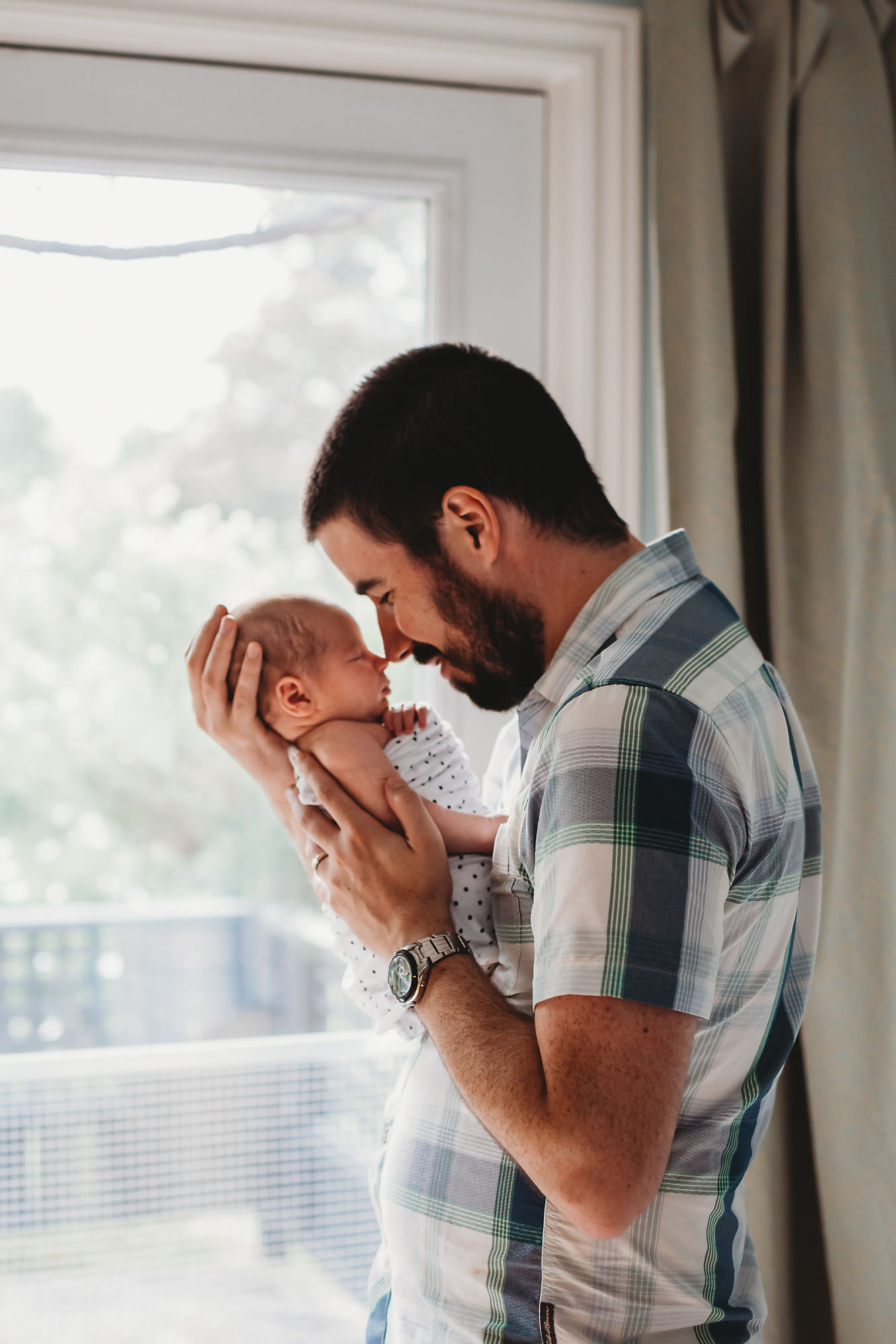 Dundas Newborn Photographer Jennifer Blaak captures a heartwarming moment between father and baby during their newborn and family lifestyle photography session at home in Hamilton.
