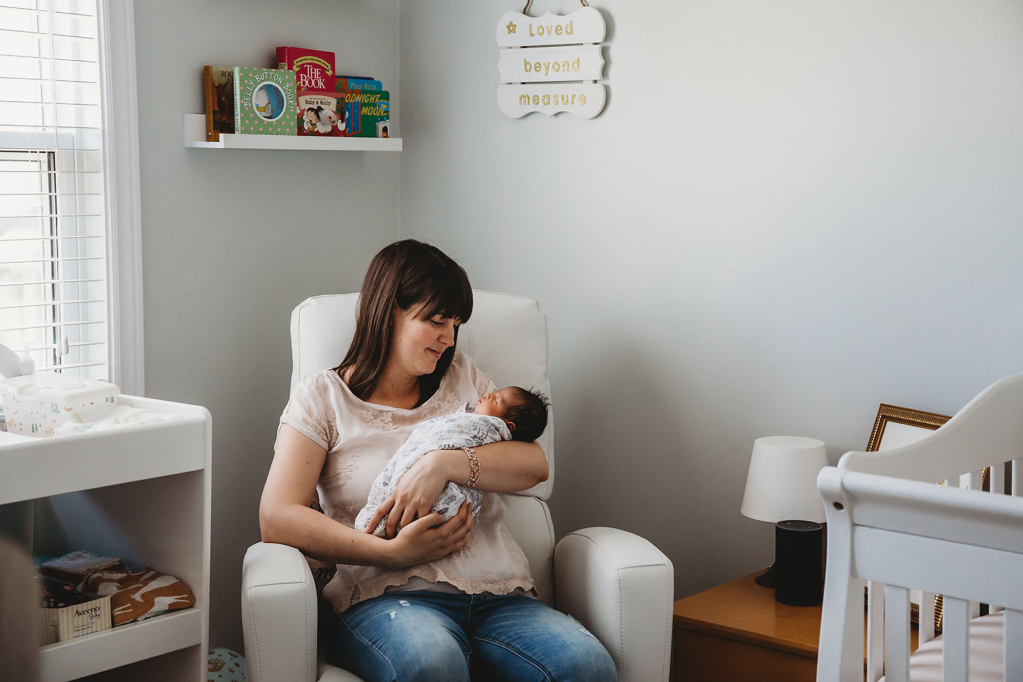 Mother and baby have a quiet moment together in the nursery during their lifestyle newborn photography session with Guelph Newborn Photographer Jennifer Blaak.