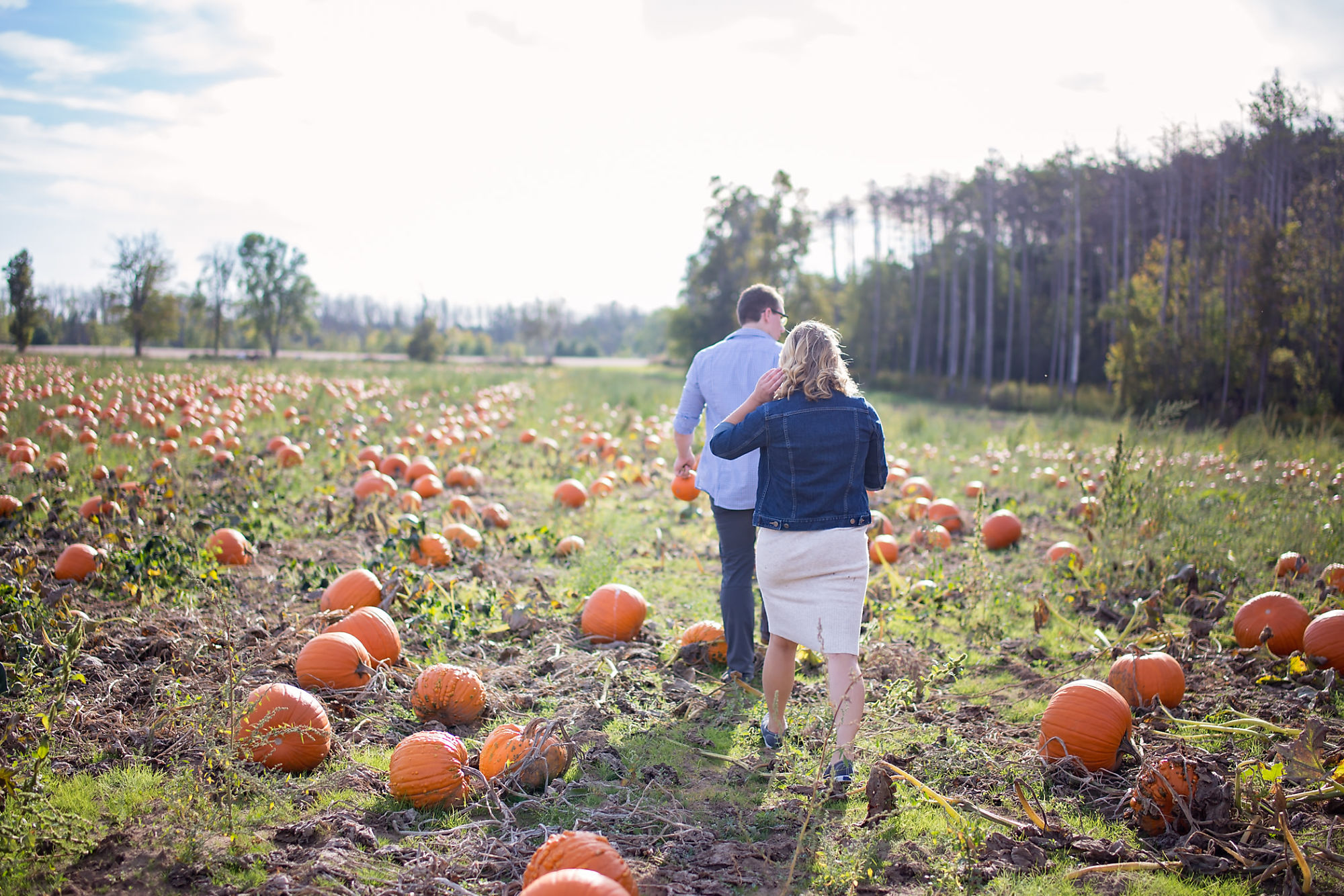 Walking through the pumpkin patch during their engagement shoot with Waterdown Engagement Photographer Jennifer Blaak.