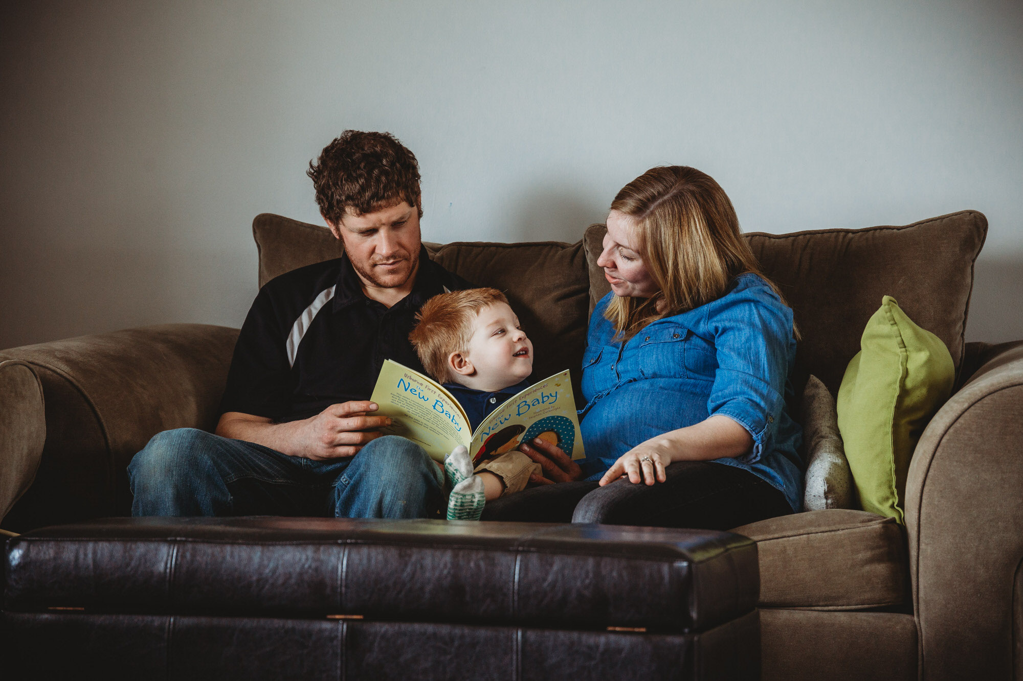 Dundas Maternity Photographer - family reading a new baby book together on the couch